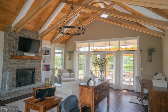 living room with a stone fireplace, high vaulted ceiling, beamed ceiling, wood-type flooring, and an inviting chandelier