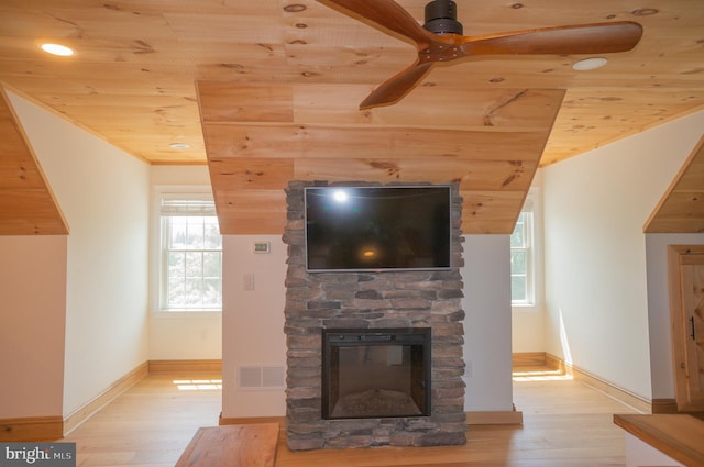 unfurnished living room featuring ceiling fan, light wood-type flooring, wood ceiling, and a fireplace