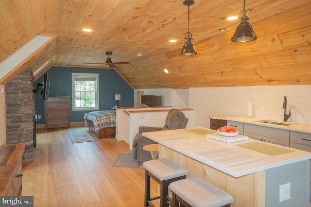 interior space with sink, wood ceiling, ceiling fan, vaulted ceiling, and light wood-type flooring