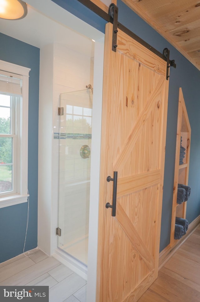 bathroom featuring an enclosed shower and hardwood / wood-style flooring