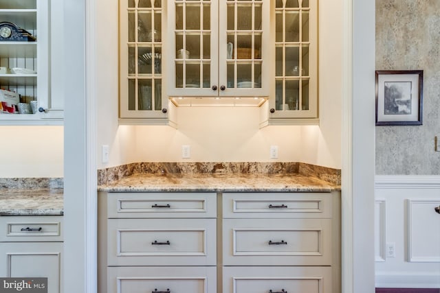 bar with light stone counters and white cabinets