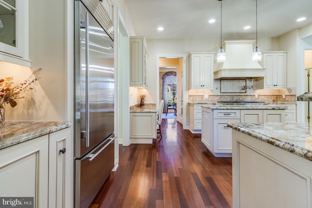 kitchen with stainless steel appliances, hanging light fixtures, and white cabinets