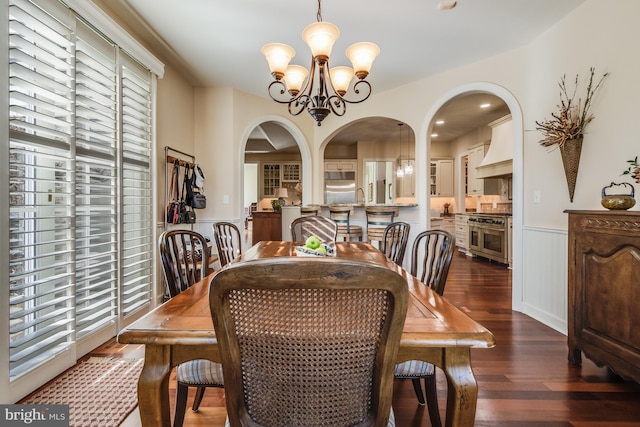 dining space featuring dark hardwood / wood-style flooring and a chandelier