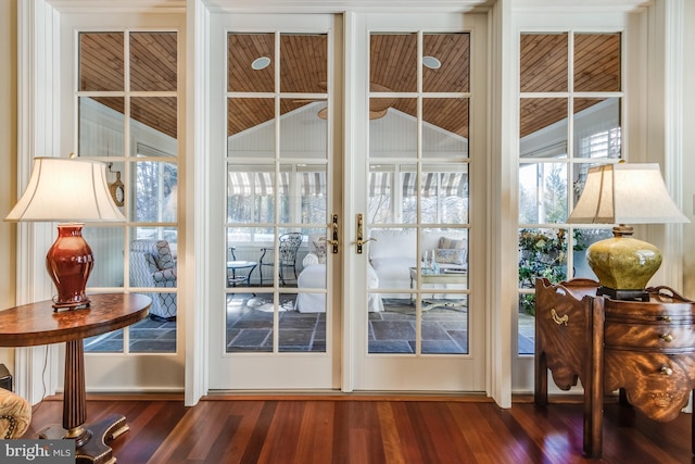 doorway to outside featuring dark hardwood / wood-style flooring, wooden ceiling, and lofted ceiling