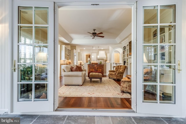 sunroom / solarium featuring a tray ceiling and ceiling fan