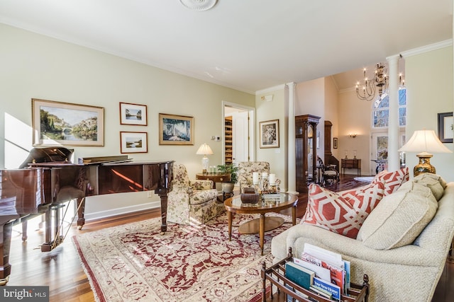 living room with decorative columns, wood-type flooring, ornamental molding, and a chandelier