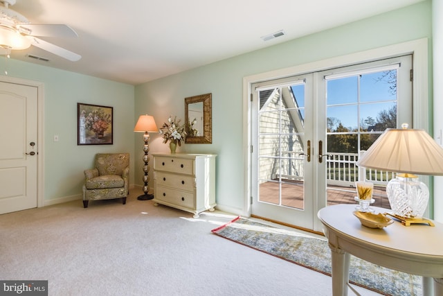 sitting room with french doors, light colored carpet, and ceiling fan