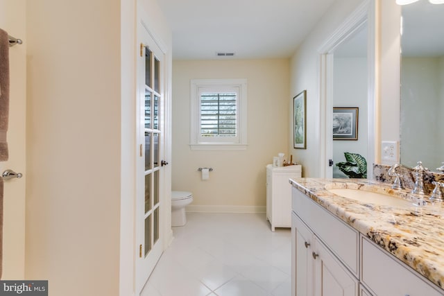 bathroom featuring vanity, tile patterned floors, and toilet