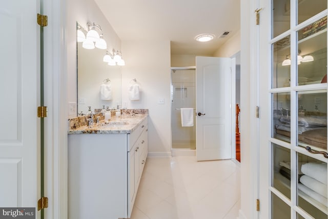 bathroom featuring tile patterned flooring, vanity, and walk in shower