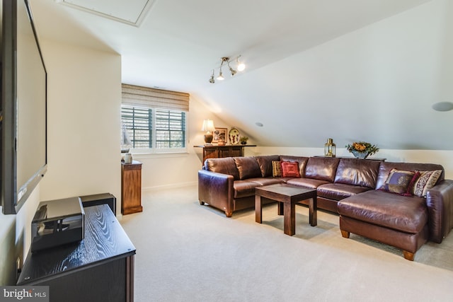 carpeted living room with rail lighting and vaulted ceiling