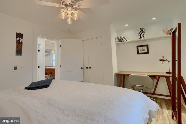 bedroom featuring light hardwood / wood-style floors, a closet, and ceiling fan