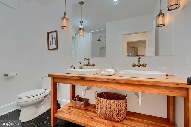 bathroom featuring tile patterned flooring, toilet, sink, and walk in shower