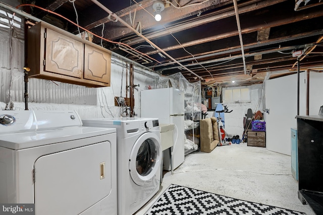 laundry area featuring cabinets and washer and clothes dryer