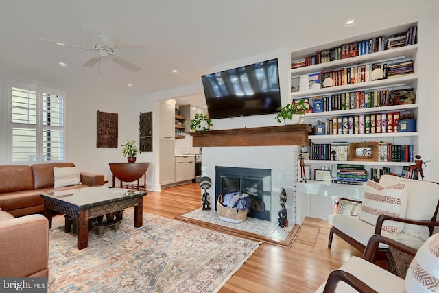 living room with ceiling fan and light wood-type flooring