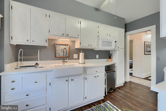 kitchen featuring ceiling fan, sink, white cabinets, and dark hardwood / wood-style flooring