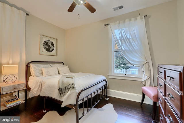 bedroom with dark hardwood / wood-style floors and ceiling fan