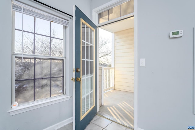 doorway to outside featuring light tile patterned floors, a wealth of natural light, and french doors