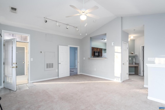 unfurnished living room featuring light carpet, lofted ceiling, rail lighting, and ceiling fan