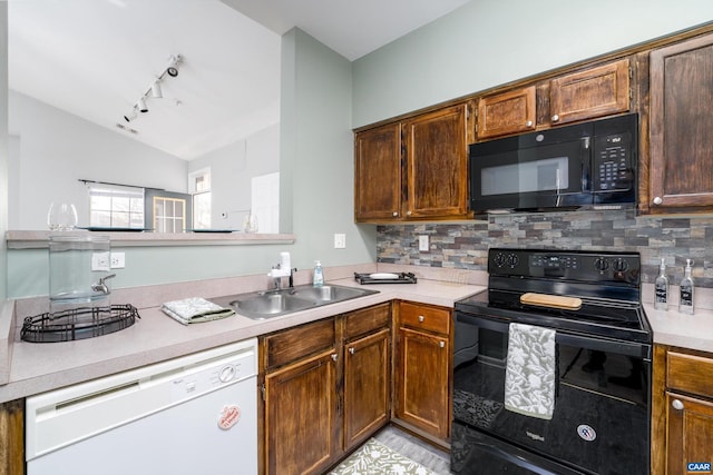 kitchen featuring vaulted ceiling, sink, backsplash, and black appliances