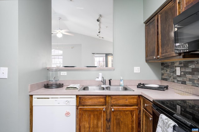 kitchen featuring sink, vaulted ceiling, white dishwasher, ceiling fan, and backsplash