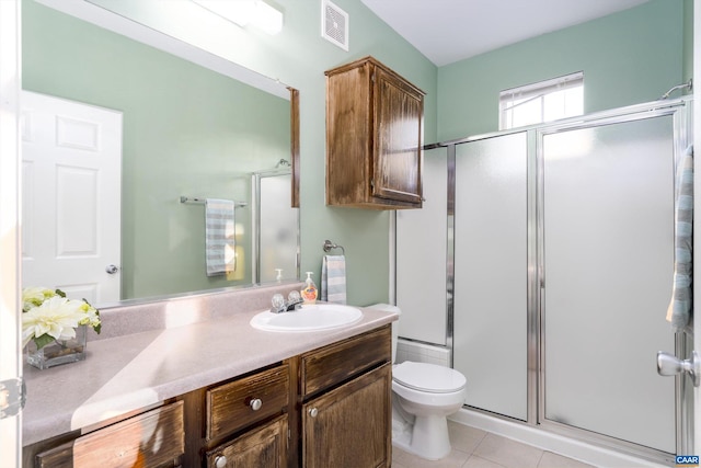 bathroom with vanity, toilet, tile patterned floors, and walk in shower