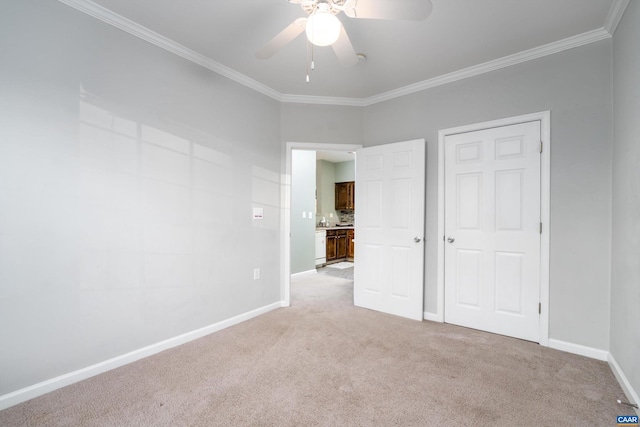 unfurnished bedroom featuring light carpet, crown molding, and ceiling fan