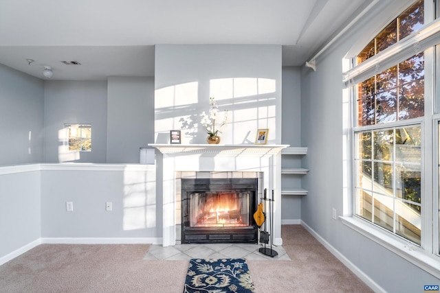 carpeted living room featuring a tile fireplace