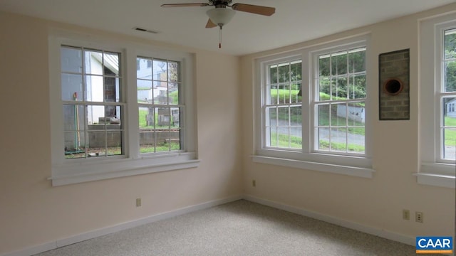 unfurnished room featuring ceiling fan and carpet