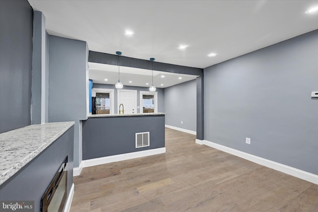 unfurnished living room with sink and light wood-type flooring