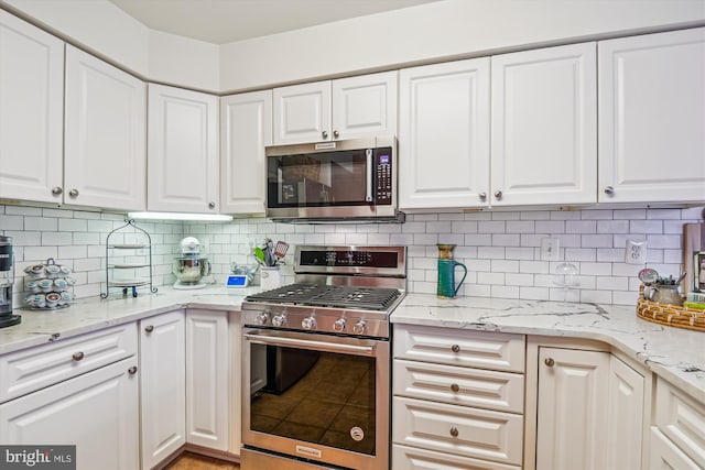 kitchen featuring white cabinetry, appliances with stainless steel finishes, and decorative backsplash