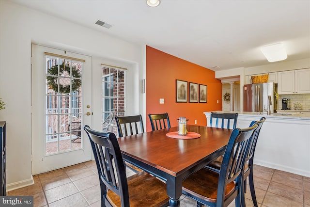 dining space with french doors and light tile patterned flooring