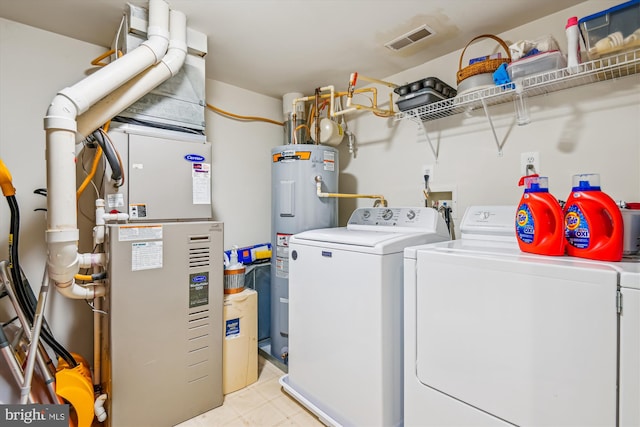 laundry room with heating unit, independent washer and dryer, and water heater