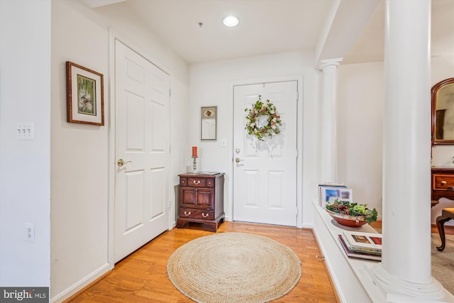 entrance foyer with decorative columns and light wood-type flooring