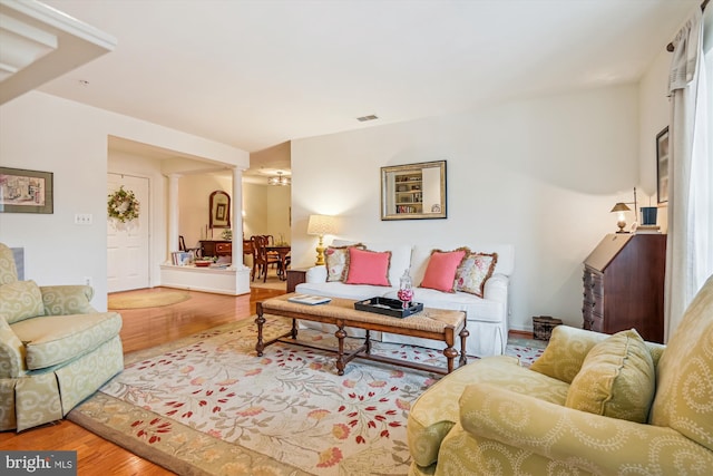 living room featuring hardwood / wood-style floors and ornate columns