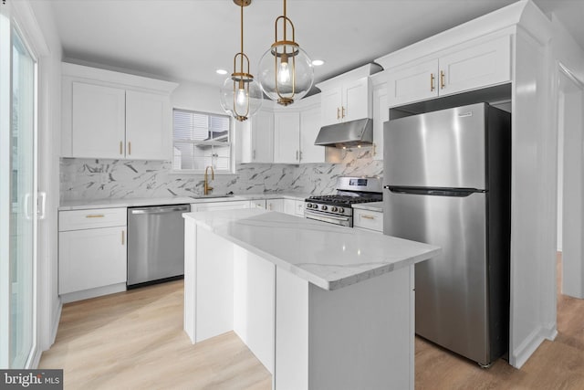 kitchen featuring sink, white cabinetry, hanging light fixtures, appliances with stainless steel finishes, and a kitchen island