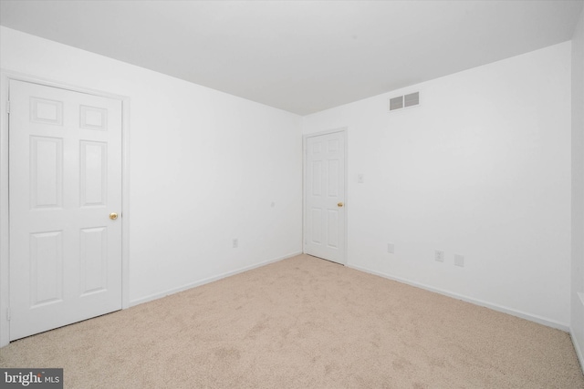 unfurnished room featuring light carpet