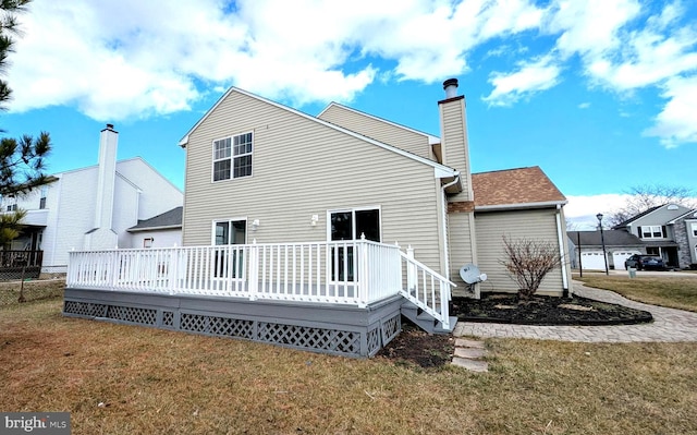 rear view of house with a wooden deck and a lawn