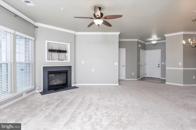 unfurnished living room featuring a wealth of natural light, ornamental molding, light colored carpet, and ceiling fan with notable chandelier