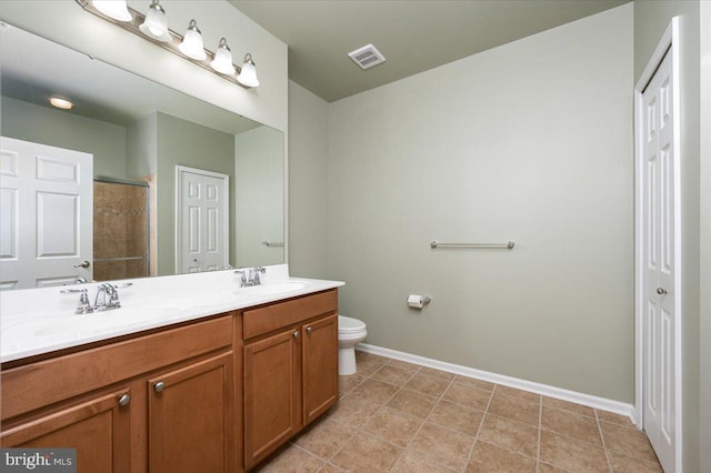 bathroom featuring vanity, tile patterned floors, toilet, and walk in shower