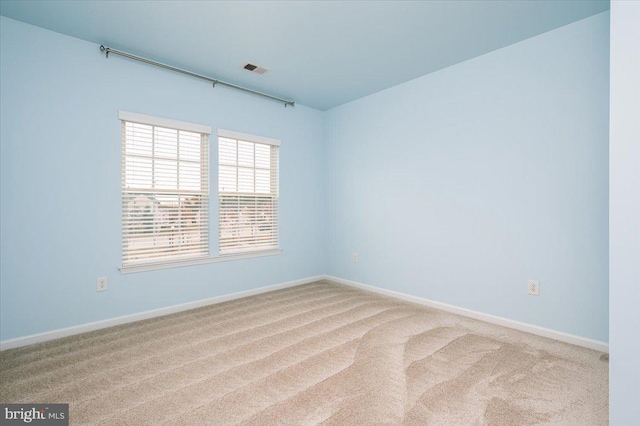 spare room featuring light carpet