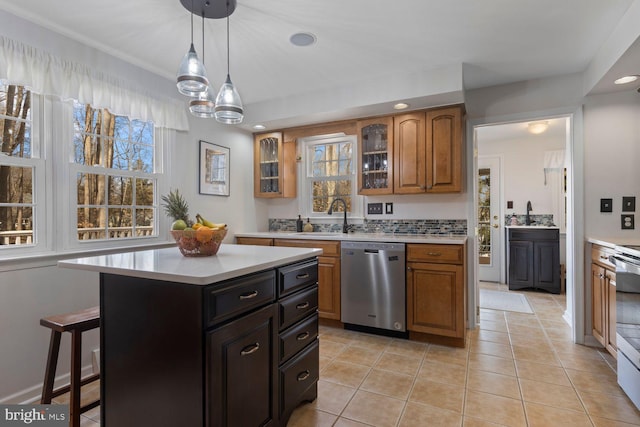 kitchen featuring dishwasher, glass insert cabinets, a center island, light countertops, and a sink