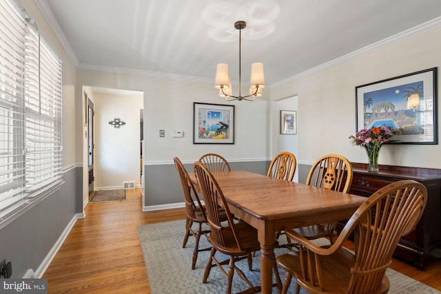 dining space with ornamental molding, plenty of natural light, wood finished floors, and baseboards