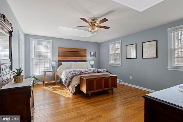 bedroom with multiple windows, a skylight, and light wood-style flooring