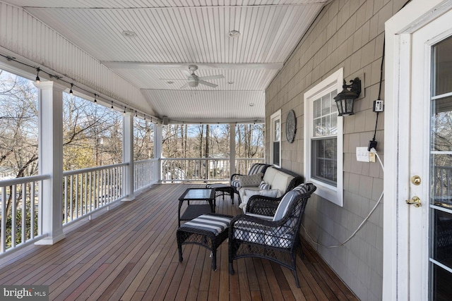 wooden terrace with covered porch and a ceiling fan