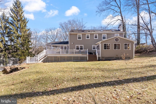 back of house featuring a yard, a chimney, fence, a wooden deck, and stairs