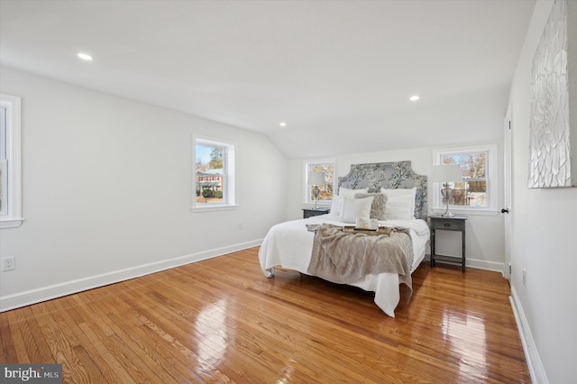 bedroom with multiple windows and hardwood / wood-style flooring