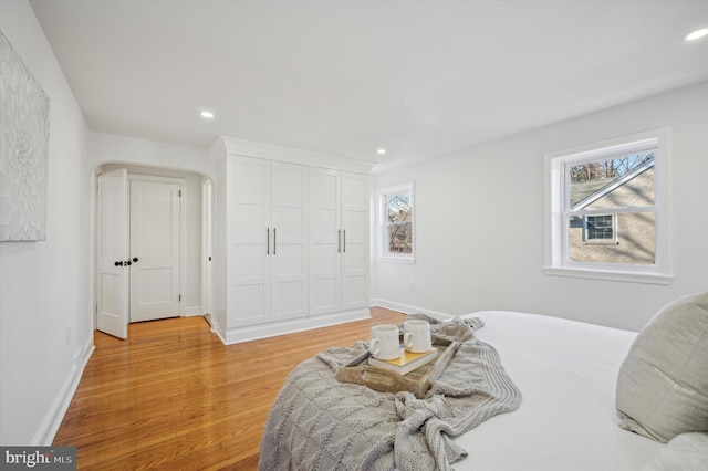 bedroom featuring recessed lighting, a closet, baseboards, and light wood-style flooring