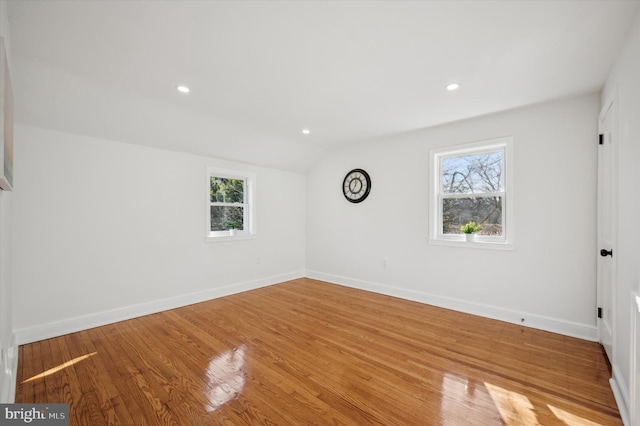 spare room featuring recessed lighting, baseboards, lofted ceiling, and wood finished floors