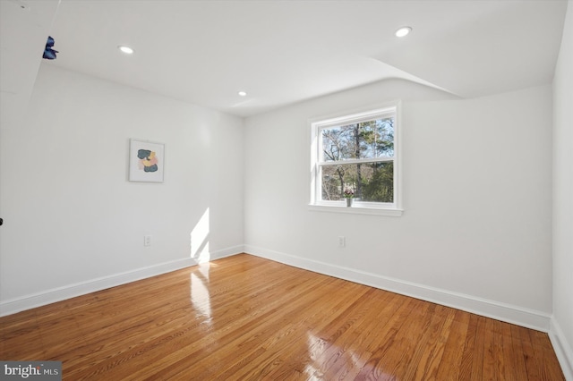 spare room with light wood finished floors, recessed lighting, and baseboards