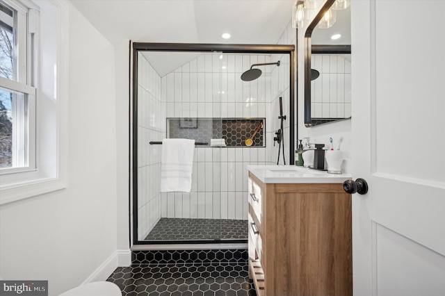 full bathroom with a shower stall, vanity, and baseboards